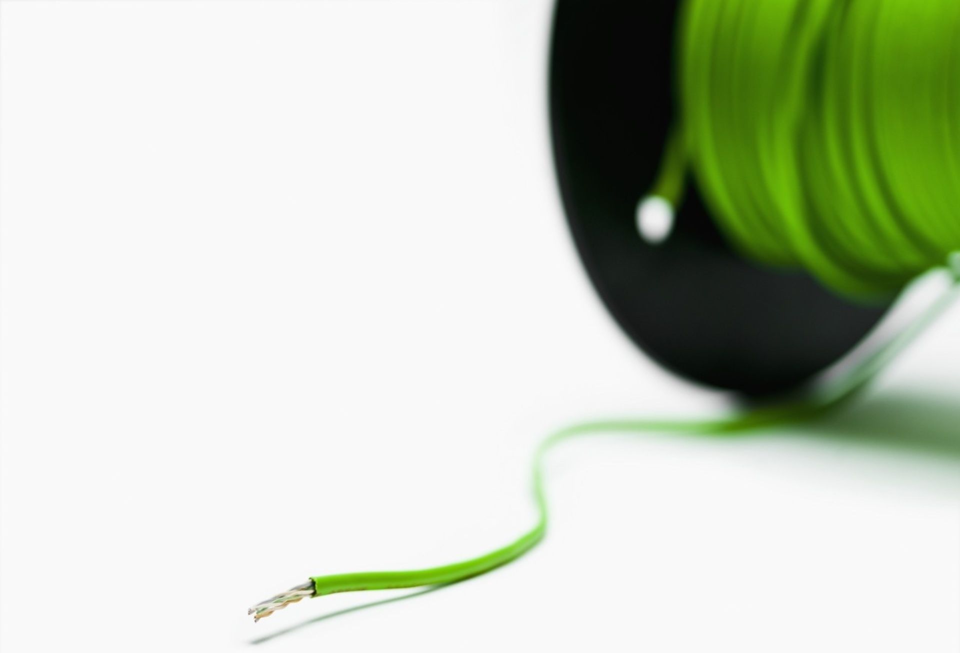 Grüne Kabelrolle mit ausgezogenem, abisoliertem Kabelende